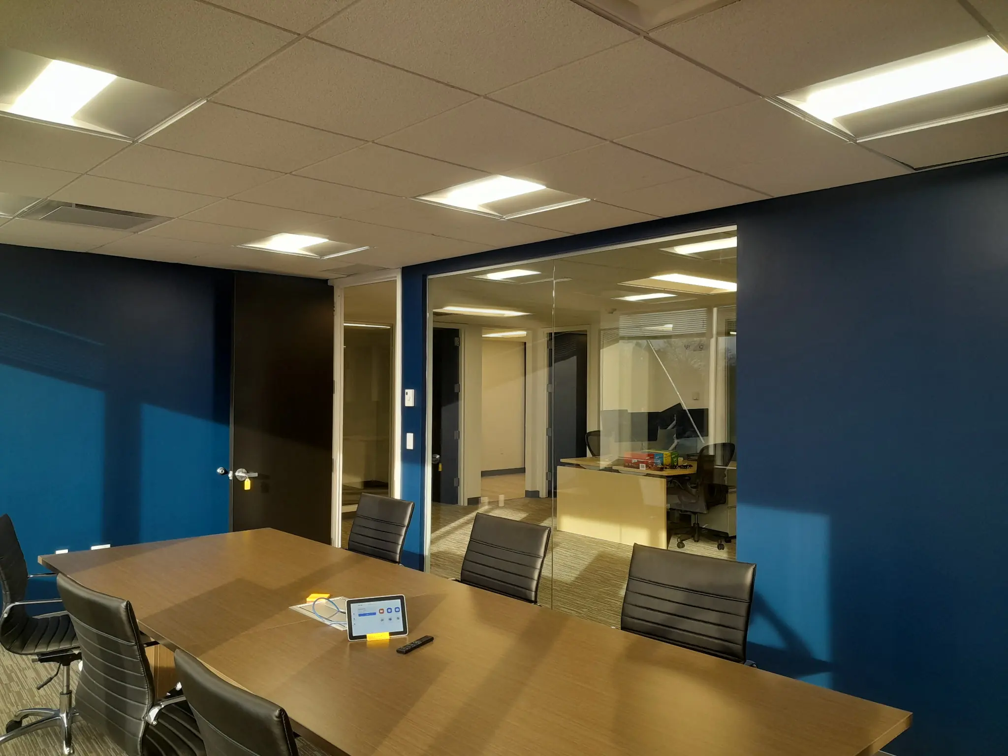 Conference room with blue painted walls and finished glass partitions.